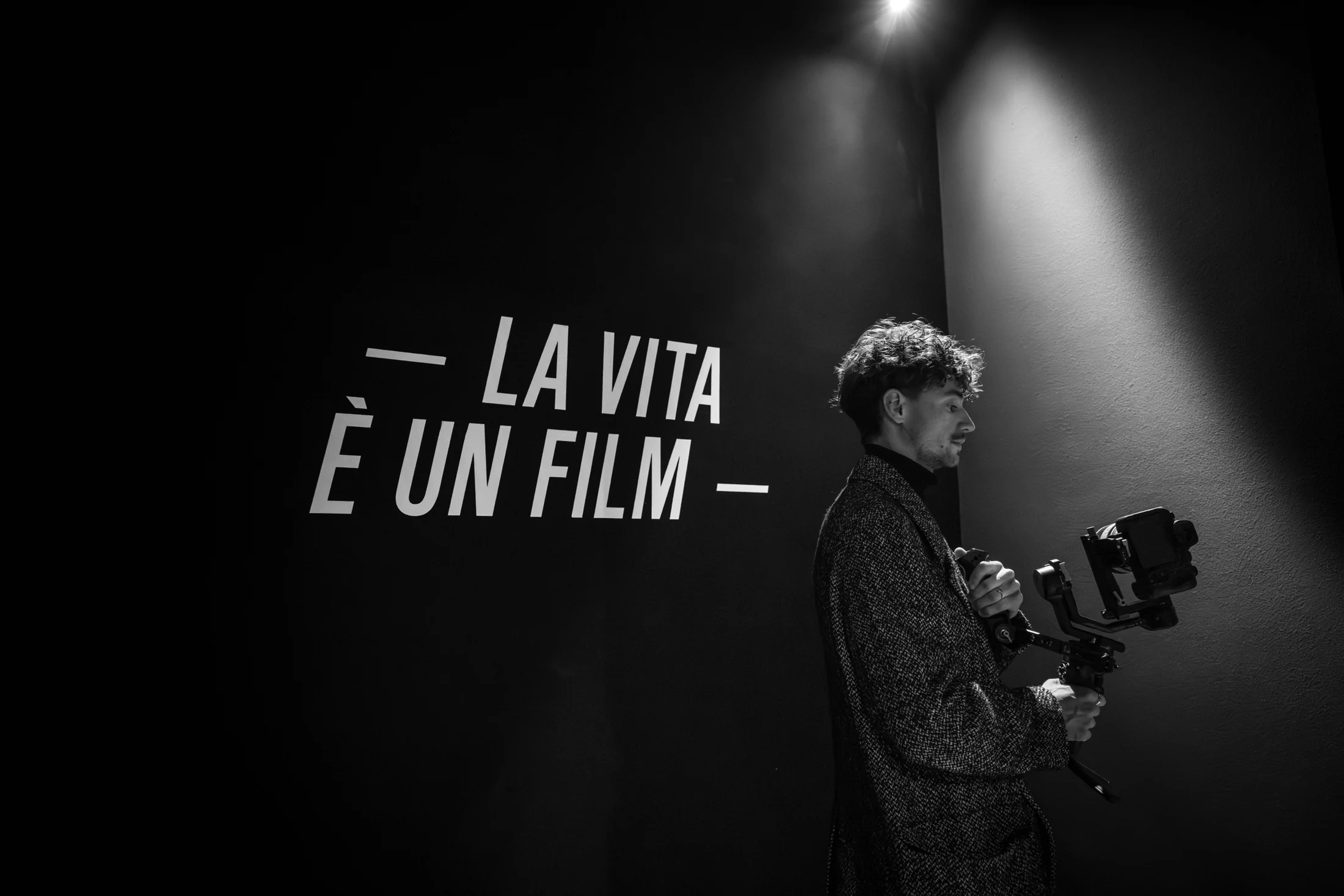 Nicolò con la videocamera accanto alla scritta La vita è un film, in bianco e nero