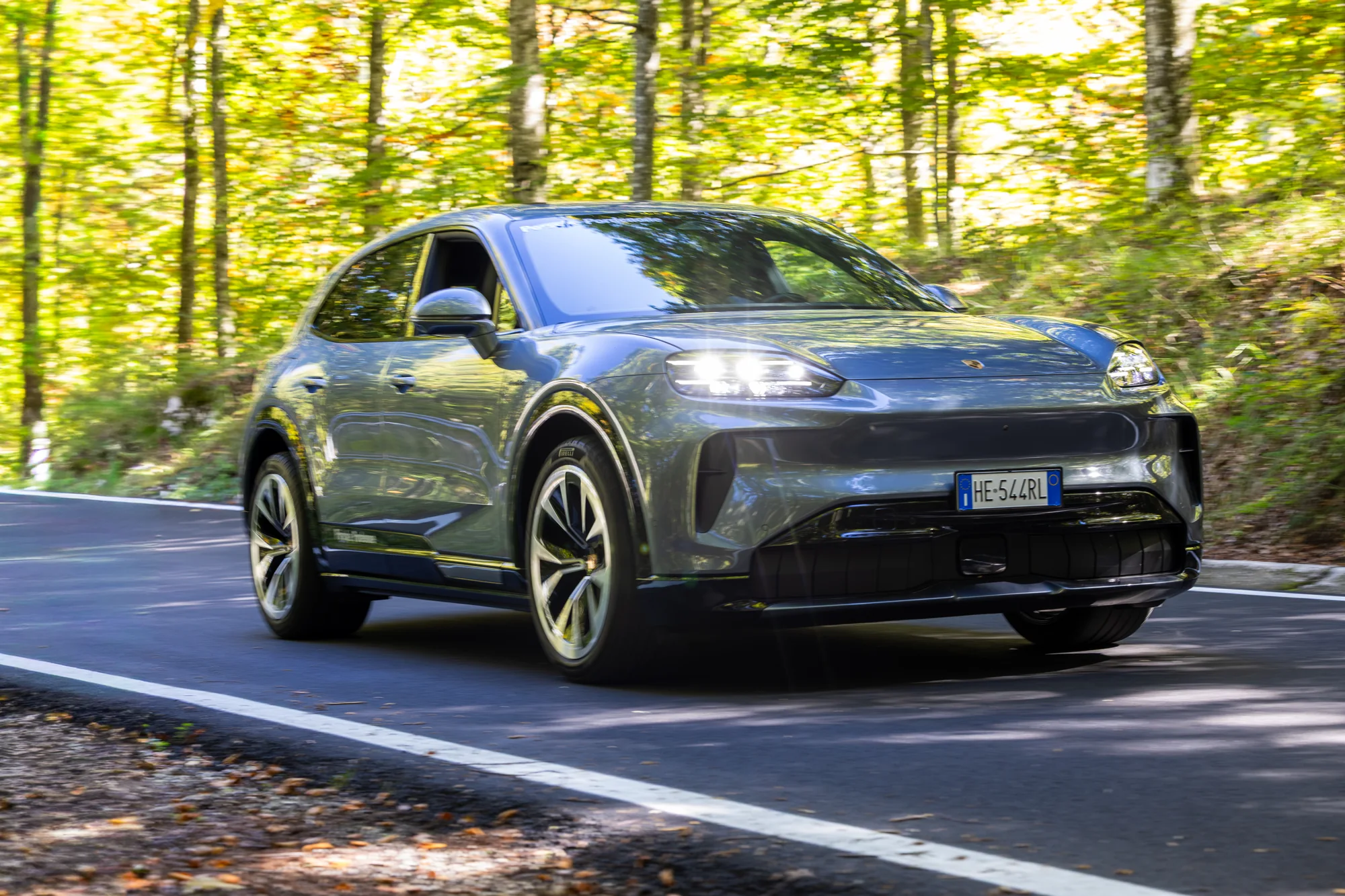 Porsche in movimento lungo una strada nel bosco